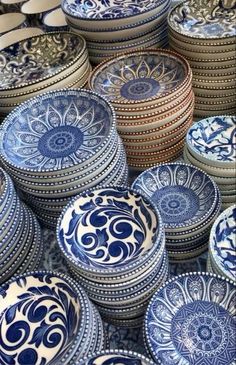 many blue and white plates stacked on top of each other