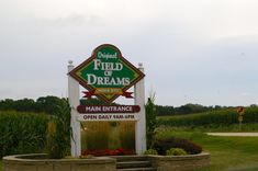 a sign that is in front of some flowers and grass with the words field of dreams above it