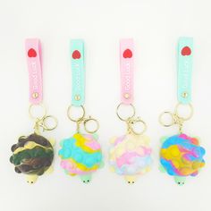 three keychains with different designs on them, one is shaped like a sheep