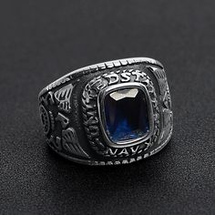 The United States Military Blue Stone Navy Ring from our Military Collection is custom molded and cast with a premium blend of surgical stainless steel that offers enhanced durability, even after exhaustive wear. The stainless steel Blue Stone Navy Ring features a deep blue ocean inspired stone centerpiece with a detailed eagle sigil on both sides of the ring. This ring is a bulkier styled ring that is great for men who want a classic everyday ring or a veteran who wants a memorable keepsake to Durable Classic Stainless Steel Jewelry, Classic Blue Stainless Steel Jewelry, Ring With Blue Stone, Navy Ring, Navy Rings, Mens Stainless Steel Rings, Navy Military, United State, Everyday Ring