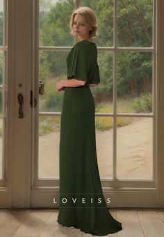 a woman standing in front of a window wearing a long green dress with short sleeves