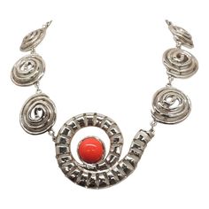 This is part of Chairish’s Costume Jewelry assortment.  1970s Modernist rhodium plated spiral links with cabochon faux-carnelian center and box clasp with a single clear round rhinestone on it necklace. Marked "U.C. Ugo Correani Made in Italy." Center:  2 inches long. Overall measures: 7 1/2 inches long by 5 1/2 inches wide. Interior circumference about 17 1/2 inches. Condition: Very good except that there is crazing to the metal coating on the clasp, which may be a problem at a later date, but Elegant Spiral Metal Jewelry, Modern Silver Spiral Jewelry, Modern Spiral Jewelry For Formal Occasions, Modern Spiral Jewelry For Formal Events, Modern Spiral Metal Jewelry, Retro Silver Metal Necklace, Retro Silver Metal Necklaces, Silver Spiral Metal Necklaces, Silver Spiral Metal Necklace