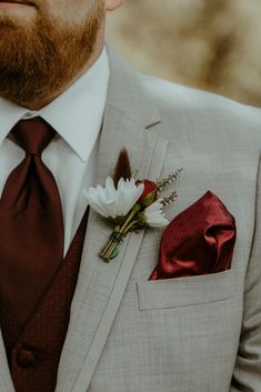 a man wearing a suit and tie with a boutonniere on his lapel