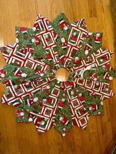 a wooden table topped with lots of green and red christmas paper decorations on top of it