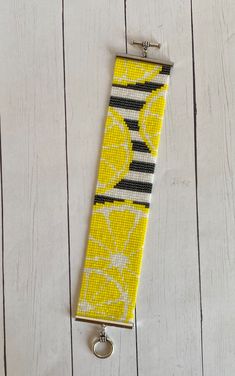 a yellow and black striped tie with lemons on it, hanging from a hook