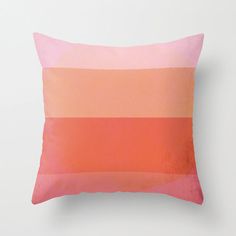 an orange and pink pillow on a white wall