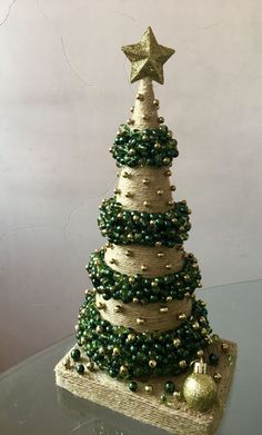 a christmas tree made out of burlocks and beads on a glass table top