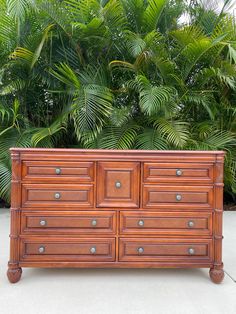 an old wooden dresser sitting in front of some plants