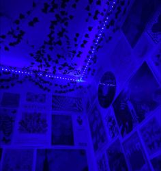 a room with purple lighting and pictures on the wall, all lit up by blue lights