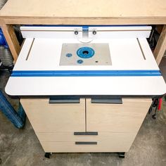 a table sawing machine sitting on top of a wooden cabinet