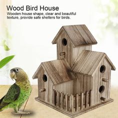 a green bird standing next to a wooden bird house