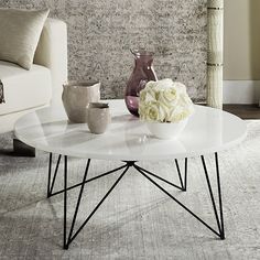 a white coffee table sitting on top of a carpeted floor next to a couch