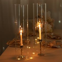 three candles are lit on a table with flowers