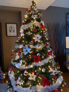 a decorated christmas tree with red and white ornaments in the center is lit by lights