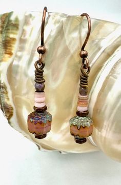 Pretty beaded boho dangle earrings with small stacked pale pink shell beads, beautiful pink and blue Czech glass and antique bronze accents. Hypo allergenic antique bronze earrings hooks. Carefully packed in organza bag and placed inside brown kraft box tied with aqua twine. An eye catching, unique addition to your boho style and makes a great handmade gift! Bohemian Pink Wire Wrapped Beaded Earrings, Pink Bohemian Jewelry With Ear Wire, Bohemian Pink Jewelry With Ear Wire, Jewelry Rustic, Bronze Earrings, Hippie Jewelry, Blue Jewelry, Brown Kraft, Shell Beads