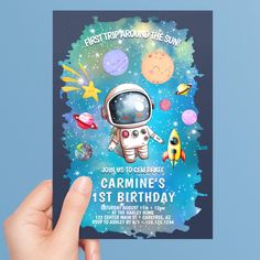 a hand holding up a birthday card with an astronaut on it