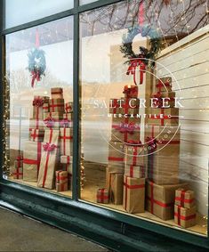 christmas presents are stacked in front of a store window