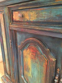 an old painted cabinet with some little figurines on it