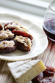 some food is sitting on a plate next to a glass of wine