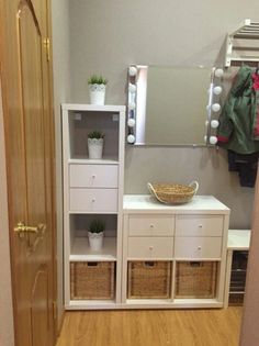 there is a white shelf with baskets on it and a mirror in the corner next to it