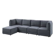 a gray sectional couch sitting on top of a white floor