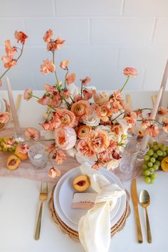 the table is set with peach colored flowers and place settings for an elegant dinner party