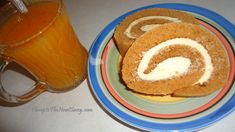 two cinnamon roll cookies on a plate next to a glass of orange juice and a mug