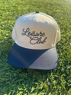 Grab your new favorite vacation hat for summer with our navy "Leisure Club" SnapBack two tone hat. Perfect for the rodeo, summer country concert or a day on the river. ---------------------- Product Details: 5 Panel Snapback Natural and Blue Brim * Classic snapback cap with premium wool blend fabric * Hard buckram. Structured * Contrasting plastic snapback closure * Contrasting eyelets and top button * ---------------------- Product Features: - Material: 8 oz./yd² (US) 13.3 oz., 50/50 cotton/polyester blend, with 20 singles - Heather Sport colors feature a 60/40 polyester/cotton blend - Classic fit for comfortable wear - 1x1 rib with spandex for enhanced stretch and recovery - Tear away label for added convenience ---------------------- CHECK OUT OUR FULL STORE: 👉 payrespects.etsy.com FOL Team-colored Flat Brim Trucker Hat For Sports Events, Casual Team-colored Trucker Hat, Team-colored Flat Brim Trucker Hat Fan Merchandise, Team-colored Adjustable Snapback Trucker Hat, Hat For Summer, Vacation Hat, Blue 5-panel Snapback Hat With Logo Patch, Summer Country, Country Concerts