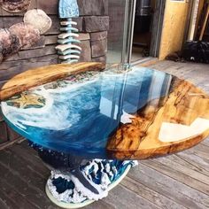 a surfboard shaped glass table sitting on top of a wooden floor next to a brick wall