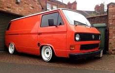 an orange van parked in front of a brick building