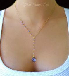 Beautiful and bright Tanzanite adorns this unique necklace! Attached are genuine tanzanite gemstone pieces 14k gold filled chain and spring clasp Length of the chain that goes around the neck (not including dangle section) is shown at 17" The Tanzanite dangle is approx 2 inches additional length Choose your favorite length during checkout The tiny gemstones are unique and will vary PACKAGINGAll Jewelry is carefully packaged for a safe arrival and is secured in a jewelry box. If you're ordering m Gold Amethyst Jewelry With Delicate Chain, Gold Gemstone Lariat Necklace With Long Drop, Gold Tanzanite Teardrop Jewelry, Gold Wire Wrapped Lariat Necklace As Gift, Gold Gemstone Lariat Necklace As Gift, Gold Lariat Necklace With Briolette Shape For Gifts, Gold Briolette Lariat Necklace As Gift, Elegant Gold Lariat Necklace With Natural Stones, Gold Tanzanite Jewelry With Faceted Design