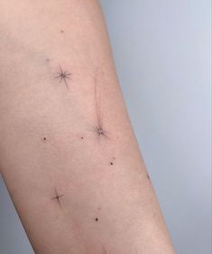 a woman's arm with small stars on it