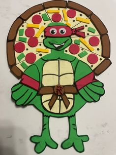 a paper cut out of a teenage mutant turtle holding a pizza on it's back