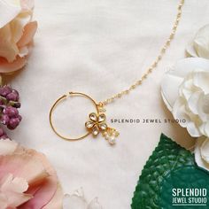 a close up of a necklace with flowers in the background