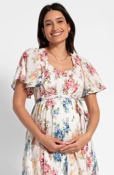 Perfect for a maternity photo shoot, this nursing-friendly midi dress is blooming with a colorful floral print that perfectly complements the fluttery sleeves. Stretchy shirred panels ensure a fit that grows with you, while discreet zippers allow easy access for nursing. Ties at back Sweetheart neck Short sleeves 51% cotton, 49% viscose Machine wash, line dry Imported Summer Dresses With Cape Sleeves And Floral Print, Maternity Summer Dress With Flutter Sleeves, Maternity Flowy Dress With Flutter Sleeves, Spring Maternity Wear Floral Dresses, Flowy Maternity Dress With Flutter Sleeves, Short Sleeve Floral Maternity Dress, Flowy Floral Print Maternity Dress, Floral Print Short Sleeve Maternity Dress, Maternity Floral Print Flowy Midi Dress