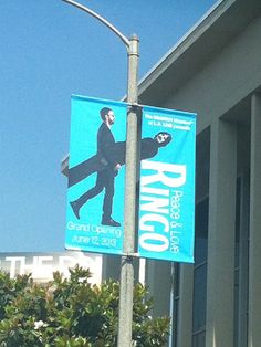 a blue street sign hanging from the side of a metal pole next to a building