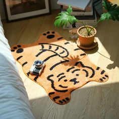 a camera sitting on top of a rug in the middle of a room with potted plants