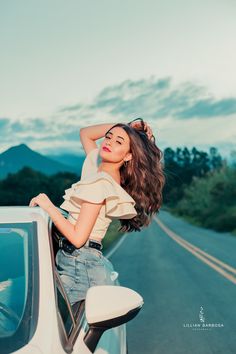 a woman leaning on the side of a car