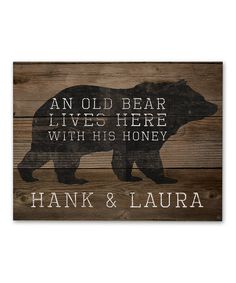 an old bear lives here with his honey sign on wooden planks that reads hank & laura