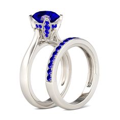 two wedding rings with blue sapphire stones on each side and the center stone is set in 18k white gold