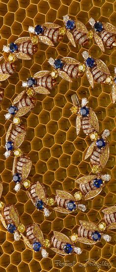 a honeycomb with blue and yellow beads on it's side, surrounded by other bees