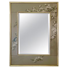 a mirror with flowers painted on it and a bird sitting on the branch next to it