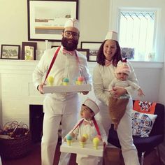 a man and woman in white outfits holding two small children