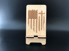 a wooden card holder with an american flag painted on the front and back, sitting on a black surface