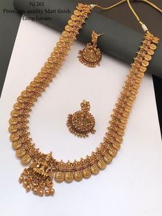 a gold necklace and earring set on display