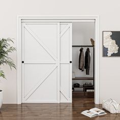 an open door in a white room with wooden floors and potted plant on the floor