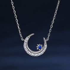 The crescent moon symbolises new beginnings and the ever-changing cycles of life. Crafted in sterling silver, this necklace features a delicate crescent moon and a twinkling blue star. This piece embodies the celestial beauty and the mystical allure of the night sky. Wearing this necklace is like carrying a piece of the night sky close to your heart. It serves as a reminder of the beauty and vastness of the universe, igniting a sense of wonder and inspiration within you.Carat Weight: 0.659 ctSto Celestial Crescent Jewelry With Birthstone, Sterling Silver Crescent Clavicle Necklace, Sterling Silver Crescent Clavicle Chain Necklace, Celestial White Gold Moon Phase Necklace, Celestial Moon Phase White Gold Necklace, Dainty Blue Moon Charm Jewelry, Dainty Blue Jewelry With Moon Charm, Elegant Blue Moon Phase Necklace, Celestial Moon-shaped Sterling Silver Necklace