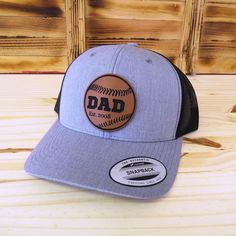 Celebrate the dads who love baseball with this custom laser engraved dad established date baseball leather patch hat. The hats are the popular trucker style snap-back that look great and are available in several colors - see available colors. Shipped in a full size box so you will receive your hat in perfect condition.  Looking for something different? We can make any custom patch for you, just message us! Item Care: Spot clean only. Do not machine wash or dry. As this item is a custom made item, refunds and returns are not offered. If there is a problem with the order please contact us and we will help to resolve. Hat Details: Material: 65% polyester and 35% cotton Size: Adult with snapback adjustable. Patch Details: Vegan friendly leatherette patch Great for: Baseball Dad Baseball Papa G Outdoor Fitted Hat For Baseball Season, Adjustable Snapback Hat With Logo Patch For Baseball Season, Baseball Season Snapback Hat With Logo Patch, Baseball Season Outdoor Cap With Letter Patch, Personalized Curved Bill Hat For Baseball Season, Adjustable Dad Hat For Baseball Season, Trucker Snapback Hat With Curved Bill For Baseball Season, Outdoor Baseball Season Cap With Letter Patch, Trucker Style Baseball Cap With Flat Bill