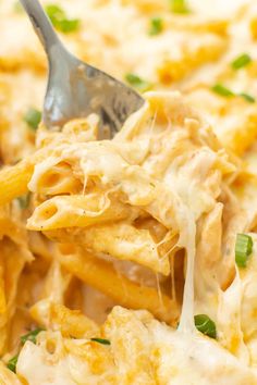 a spoon full of macaroni and cheese being lifted from the casserole dish