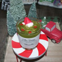 a green smoothie with a red and white santa hat on top sitting on a plate